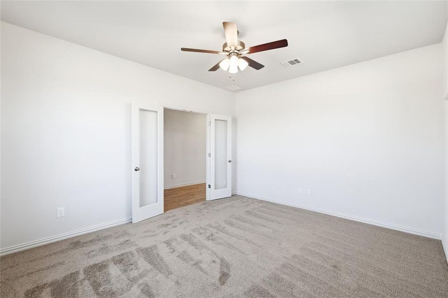 Empty room with carpet and a ceiling fan