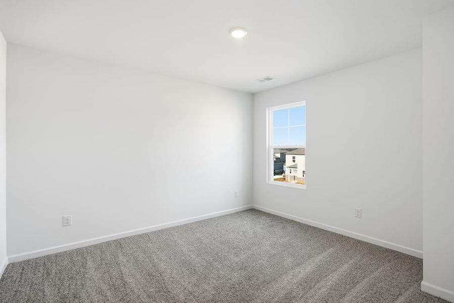 A room with a window and carpet.