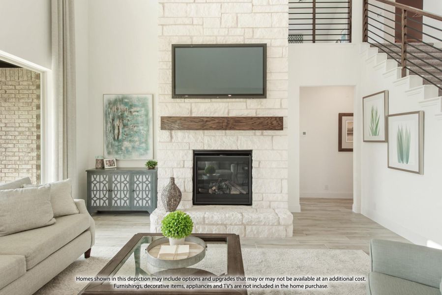 Living room with white stone fireplace, wood mantel, wall-mounted TV, and high ceilings near staircase