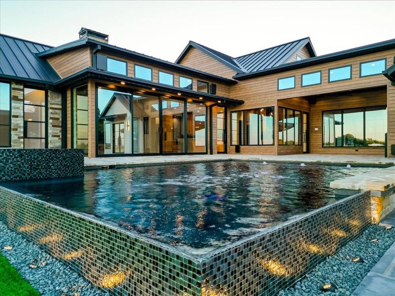 Rear view of property with a standing seam roof, a metal roof, and a patio area