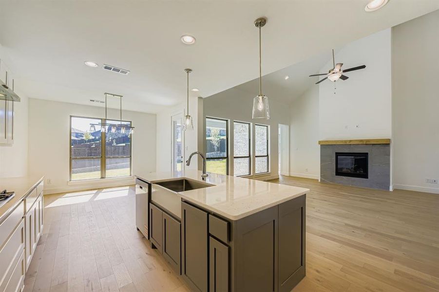 Kitchen with decorative light fixtures, recessed lighting, plenty of natural light, an island with sink, and light stone countertops Kitchen with decorative light fixtures, recessed lighting, plenty of natural light, an island with sink, and light stone countertops