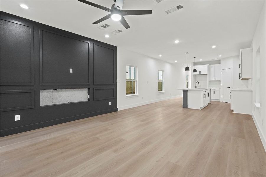 Unfurnished living room with light wood-style floors, ceiling fan, and recessed lighting Unfurnished living room with light wood-style floors, ceiling fan, and recessed lighting