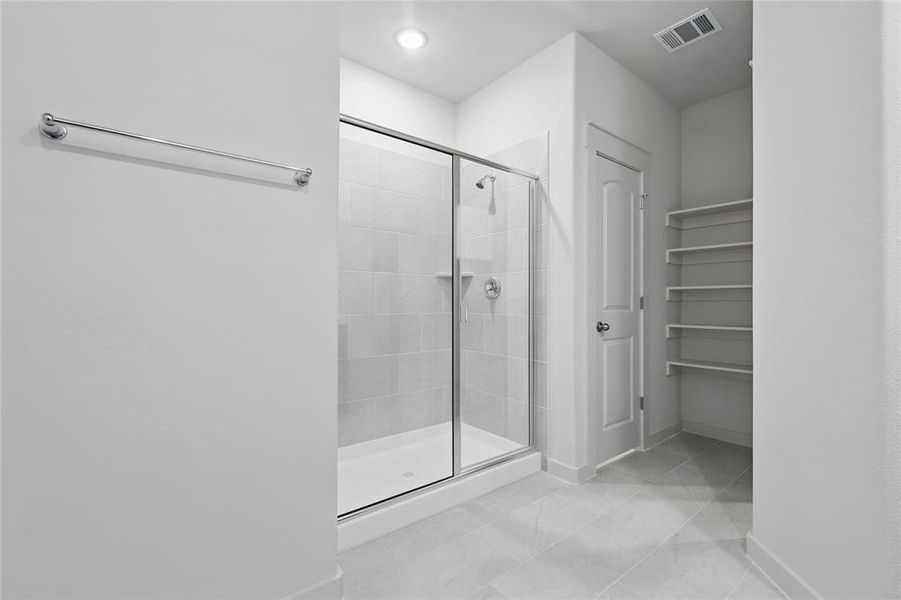Bathroom with a stall shower and a closet