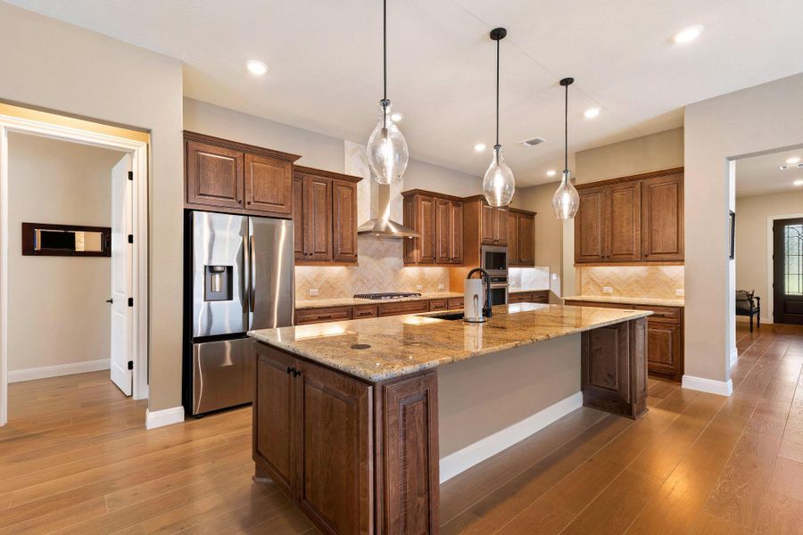 A chef's kitchen showcasing rich wood cabinetry and gleaming stainless steel appliances. A chef's kitchen showcasing rich wood cabinetry and gleaming stainless steel appliances.