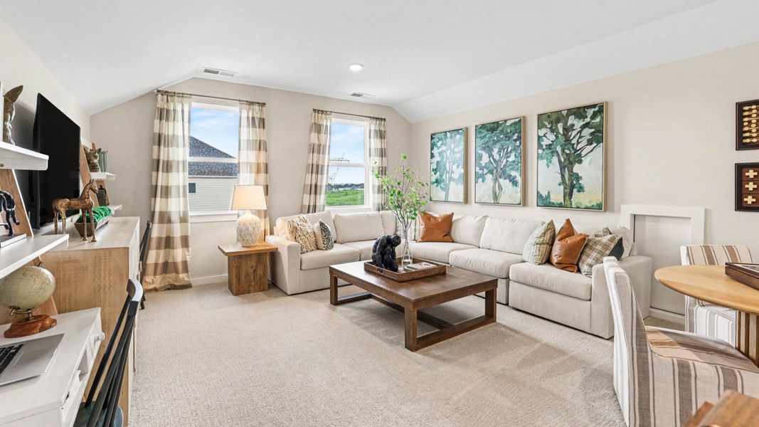 Spacious loft area with carpet and windows
