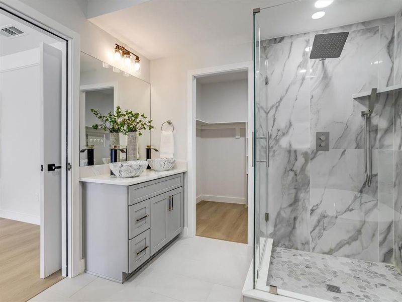 Primary ensuite contemporary bathroom featuring a spacious glass-enclosed shower with large format marble-look tile walls and a pebble-tiled floor Primary ensuite contemporary bathroom featuring a spacious glass-enclosed shower with large format marble-look tile walls and a pebble-tiled floor