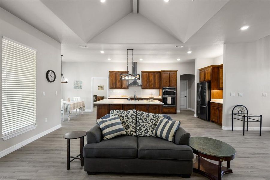 Living room featuring recessed lighting, light wood-type flooring, and arched walkways