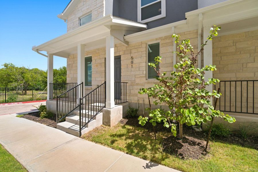 Stone masonry accents and a covered porch establish welcoming curb appeal.
