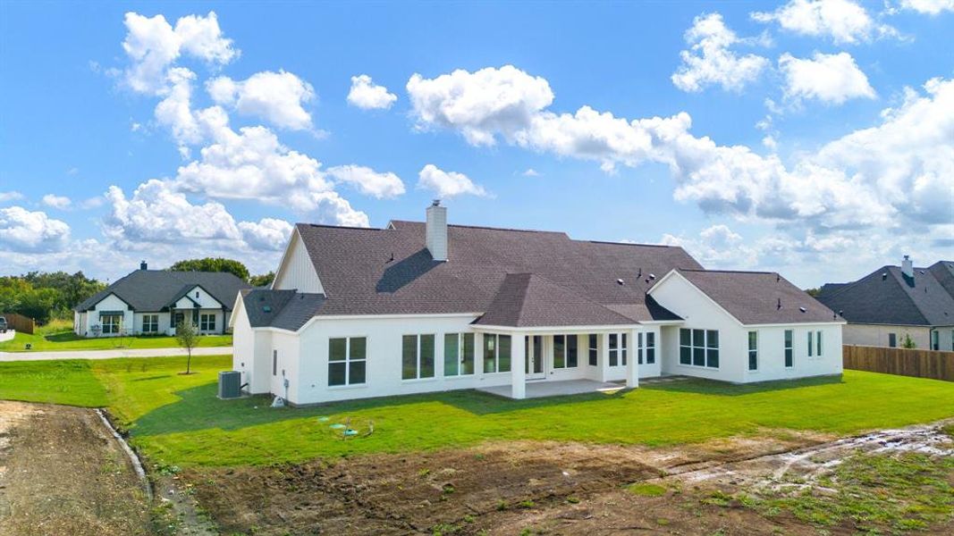 Back of house featuring a lawn and central AC unit