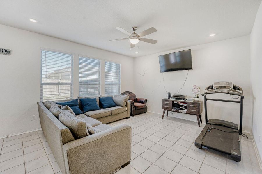 Living area featuring ceiling fan, light tile patterned flooring, and recessed lighting