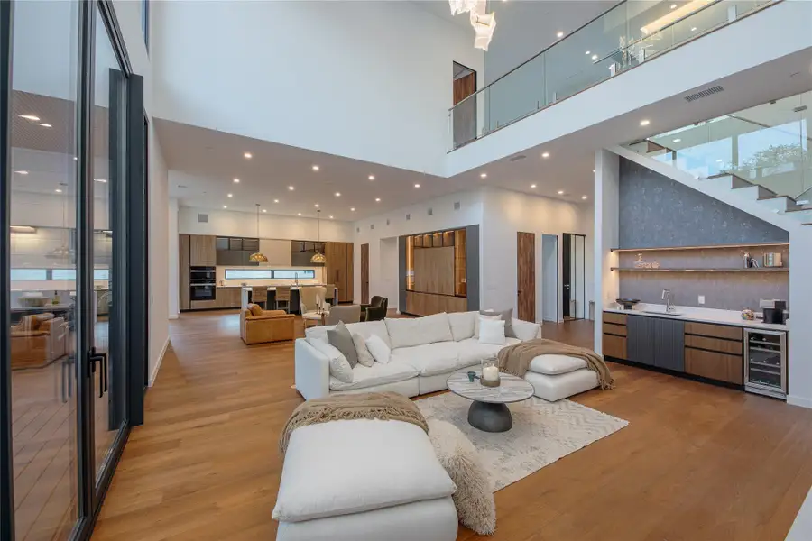 An open concept design, this residence features a modern kitchen and a sleek dry bar, perfect for entertaining.