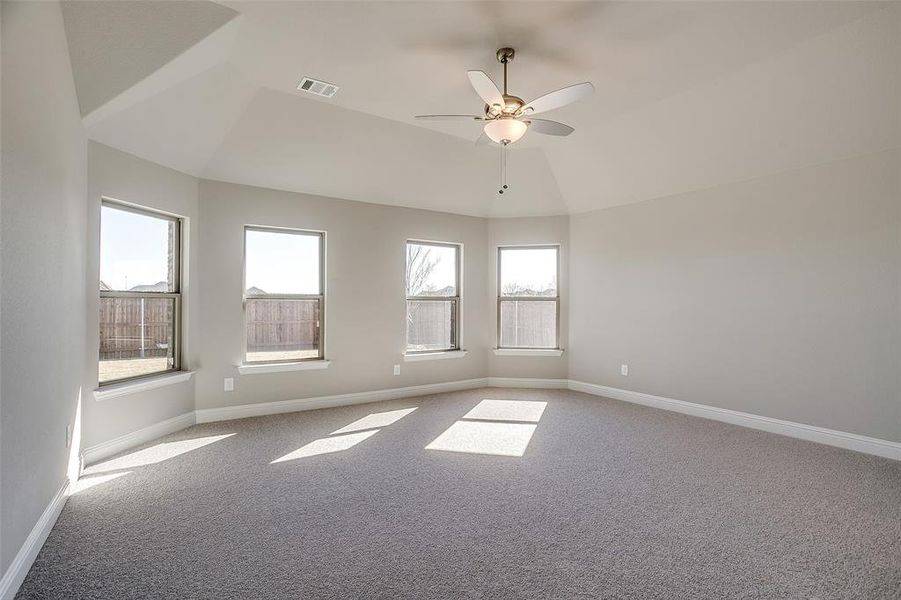 Carpeted spare room featuring lofted ceiling and ceiling fan Carpeted spare room featuring lofted ceiling and ceiling fan