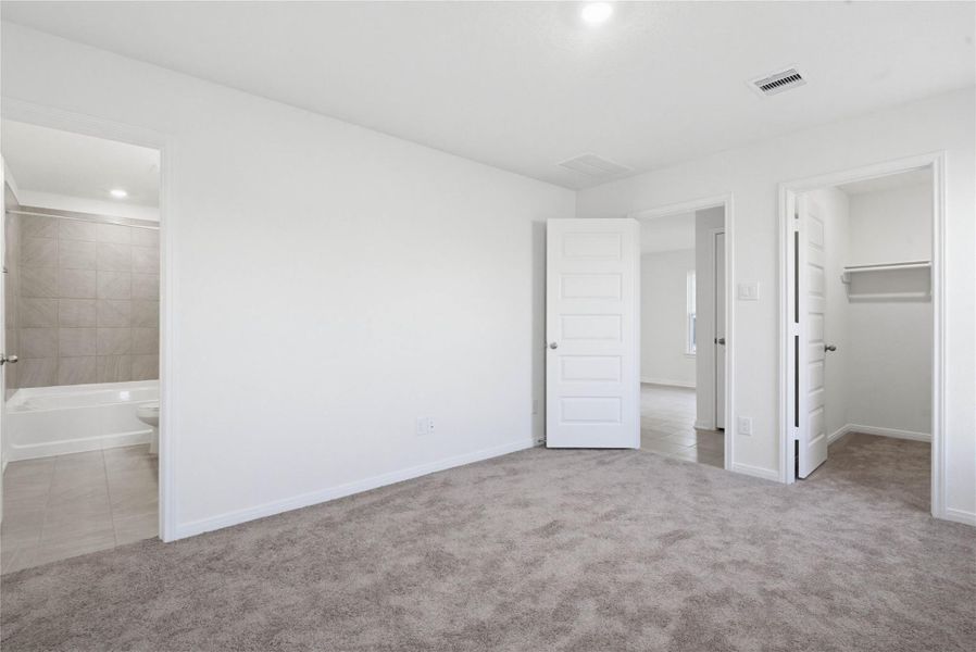Additional view of the primary bedroom looking towards the primary bathroom and walk-in closet.