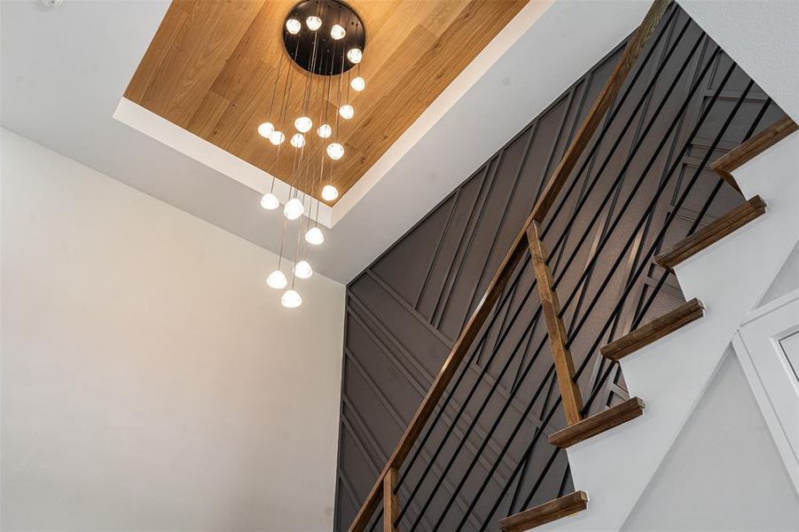 Staircase with wood art wall detail and stunning chandelier Staircase with wood art wall detail and stunning chandelier