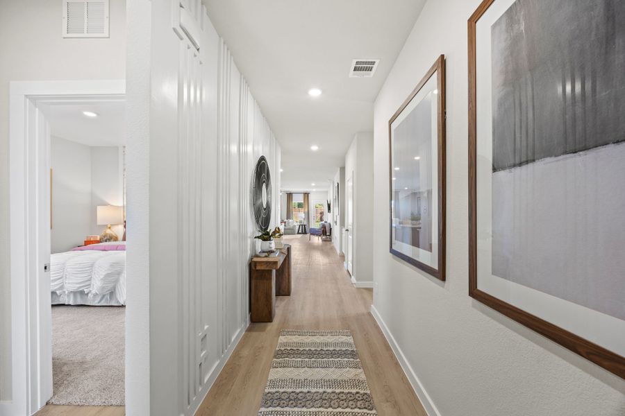 A hallway with a bed and a mirror.