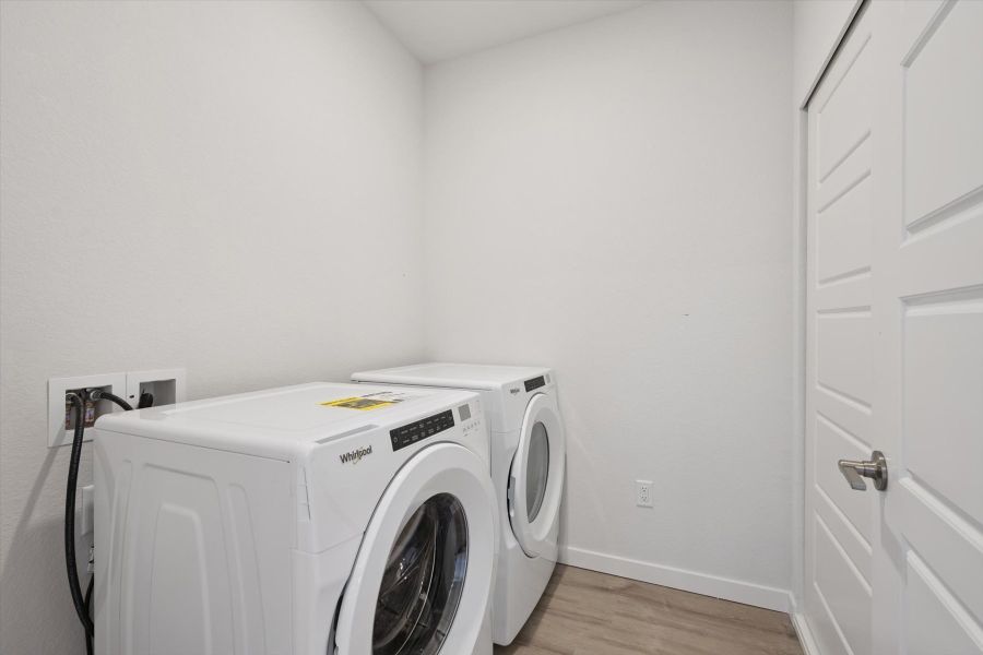 A white washing machine in a room. A white washing machine in a room.