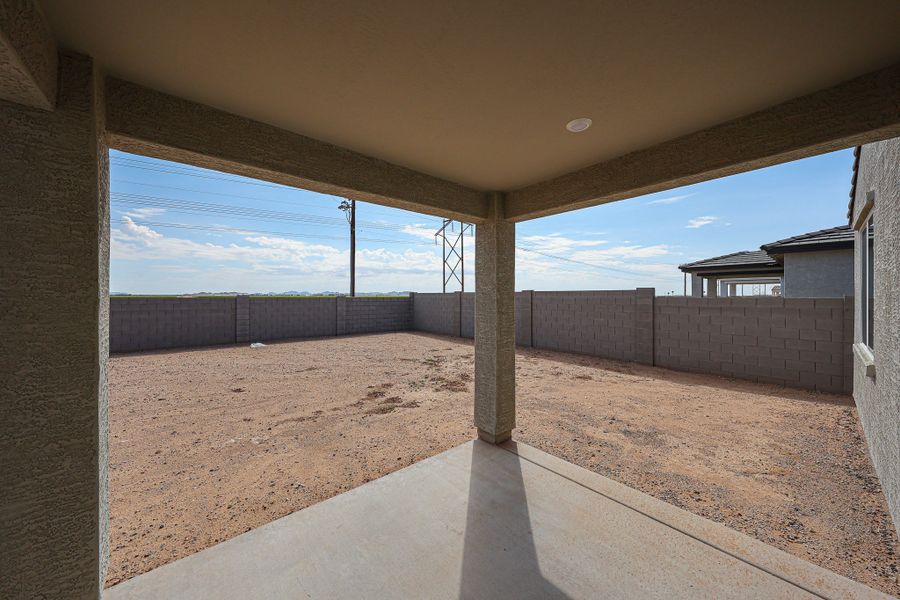 A concrete walkway with a fence and a building in the background.