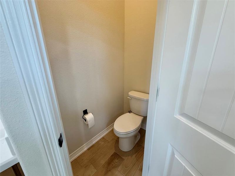 Bathroom with toilet and wood finished floors