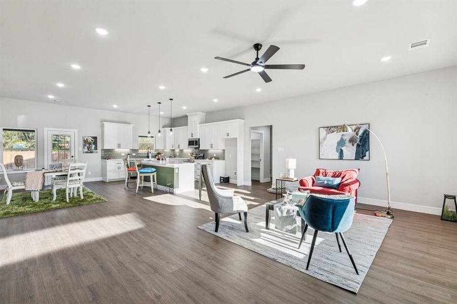 Living area with recessed lighting, a ceiling fan, and dark wood-type flooring