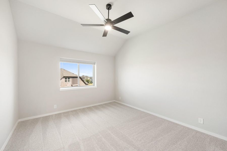 Empty bedroom with vaulted ceiling, black ceiling fan, carpet flooring, and single window