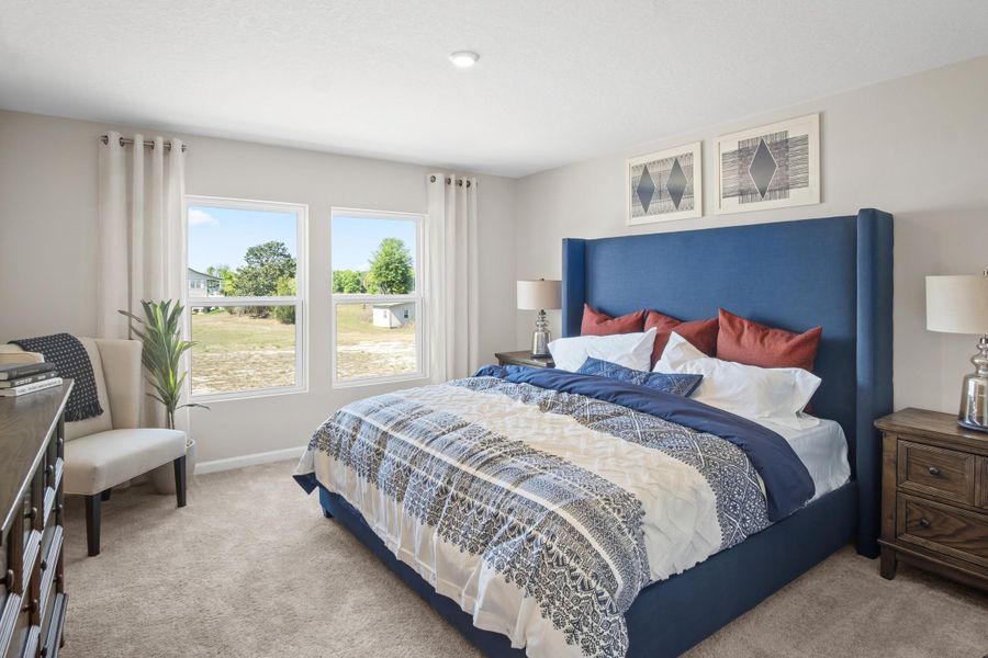 A bedroom with a bed and a chair.