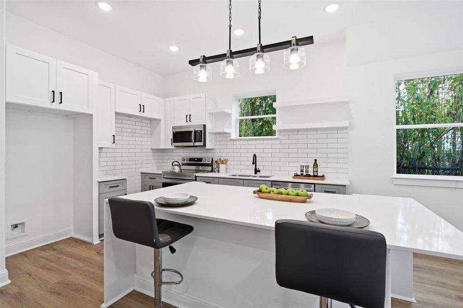 Open concept kitchen, dining and living room, with lots of natural light.