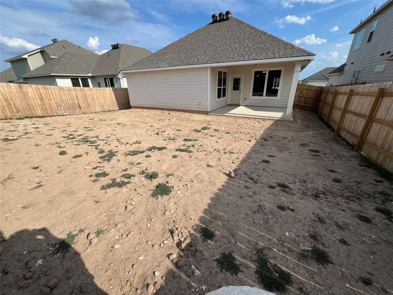 Back of house featuring a patio, a shingled roof, and a fenced backyard Back of house featuring a patio, a shingled roof, and a fenced backyard