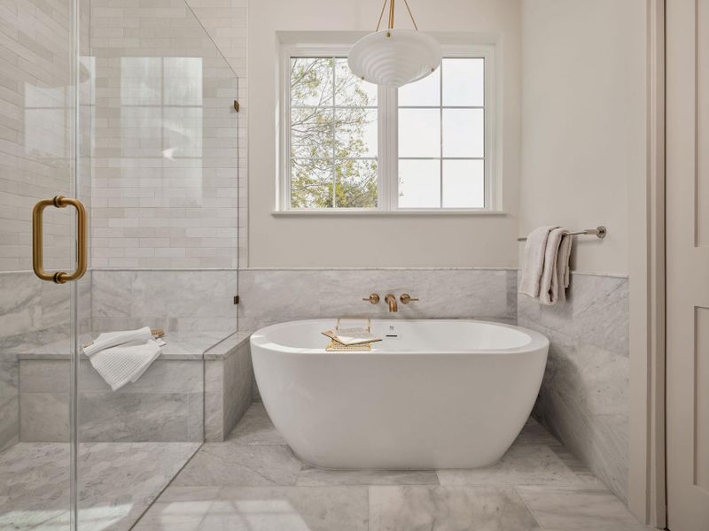 Full bathroom featuring tile walls, a freestanding tub, wainscoting, and a shower stall Full bathroom featuring tile walls, a freestanding tub, wainscoting, and a shower stall