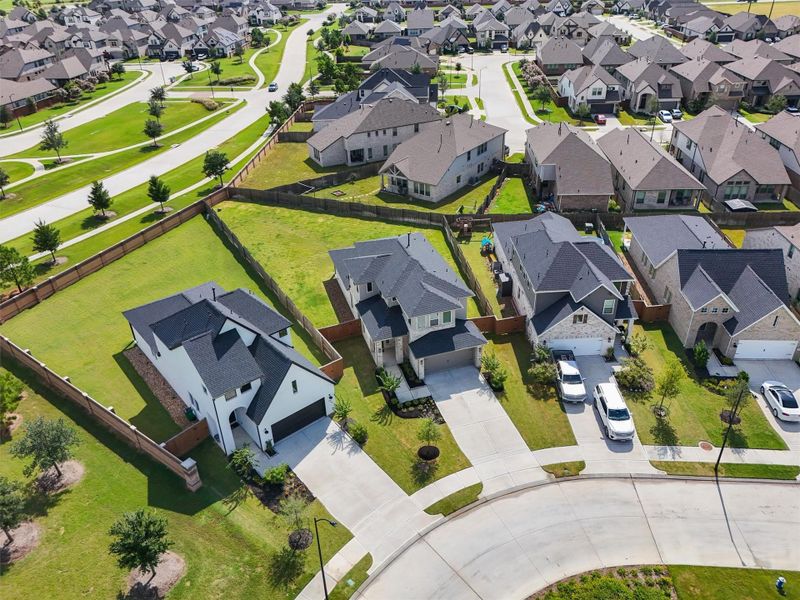 This aerial view highlights the home's spacious lot, which is significantly larger than many of the surrounding properties. The location offers easy access to the main roads and is conveniently situated near the entrance to this section of the community.