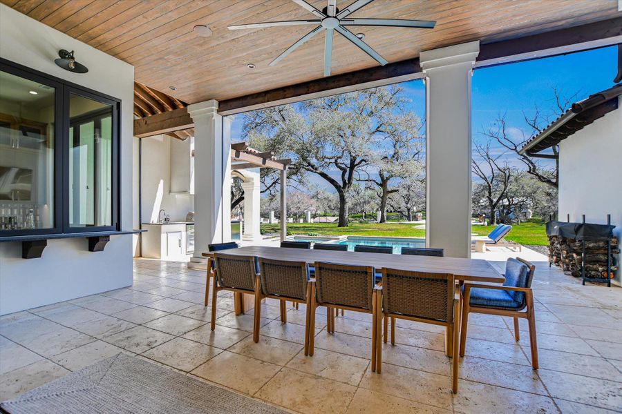 Dining space with wooden ceiling, stone tile flooring, and a ceiling fan