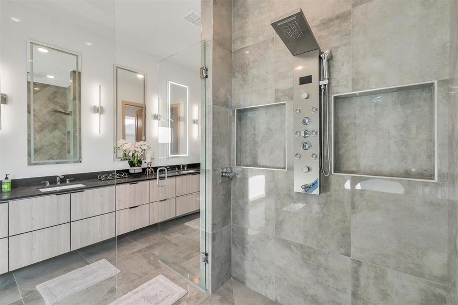 Bathroom with tiled shower and vanity