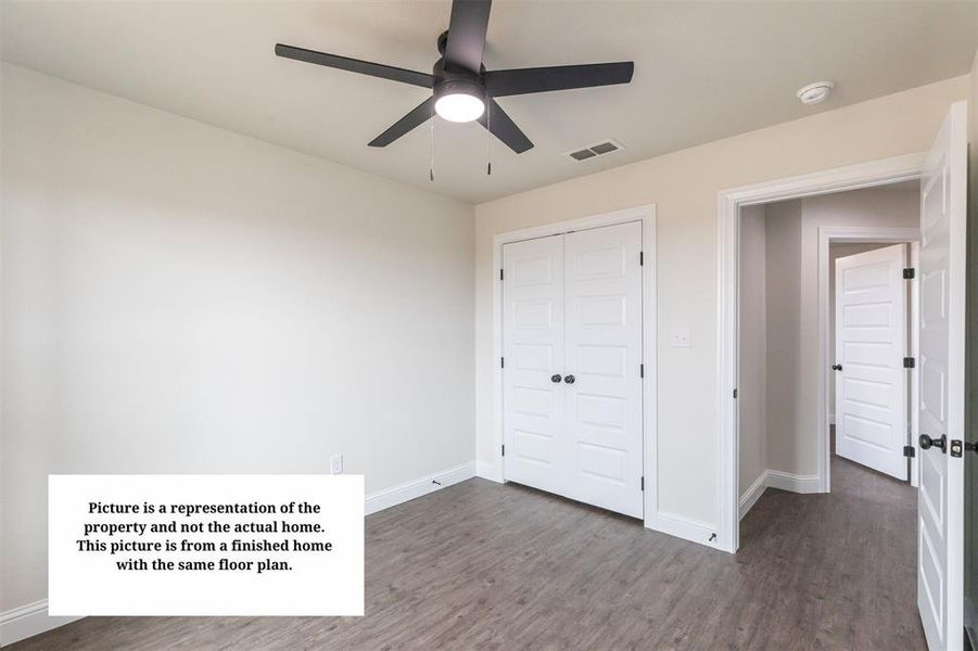 Bedroom featuring wood-finish flooring, a ceiling fan with integrated lighting, and white walls