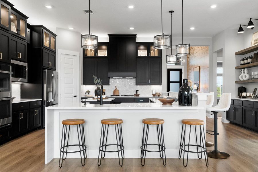 A well-lit kitchen with sleek dark cabinetry, bright white countertops, and a charming breakfast bar. A well-lit kitchen with sleek dark cabinetry, bright white countertops, and a charming breakfast bar.