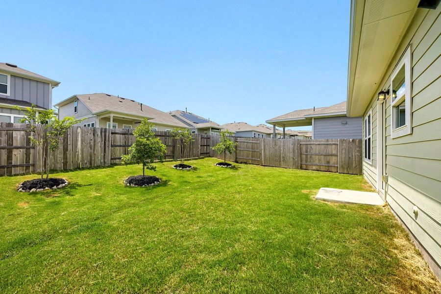 A well-maintained green yard with young trees offers a private and serene outdoor escape. A well-maintained green yard with young trees offers a private and serene outdoor escape.
