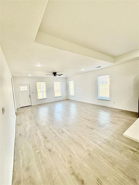 Unfurnished living room with light wood finished floors and ceiling fan