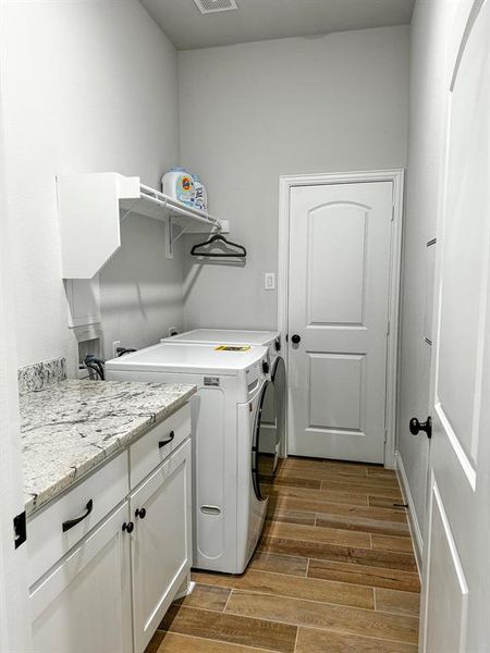 Large laundry room with ample counter space and storage plus a closet with shelves