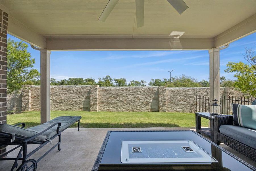 The stone wall at the back of the property gives an additional element of privacy to the patio.