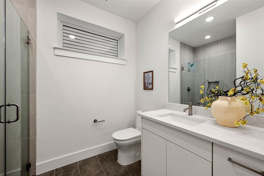 A well-appointed bathroom features a modern vanity with a white countertop and a glass-enclosed shower. A well-appointed bathroom features a modern vanity with a white countertop and a glass-enclosed shower.