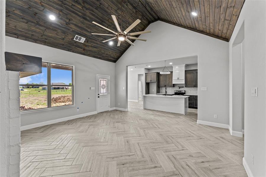 Unfurnished living room featuring high vaulted ceiling, a ceiling fan, recessed lighting, and wood ceiling Unfurnished living room featuring high vaulted ceiling, a ceiling fan, recessed lighting, and wood ceiling