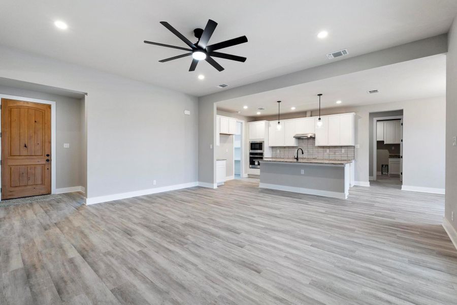 Unfurnished living room featuring ceiling fan, recessed lighting, and light wood-style flooring