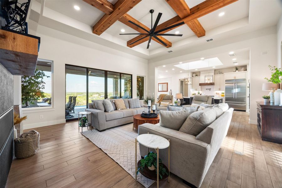 Living room with ceiling fan, hardwood / wood-style floors, a skylight, coffered ceiling, and beamed ceiling Living room with ceiling fan, hardwood / wood-style floors, a skylight, coffered ceiling, and beamed ceiling