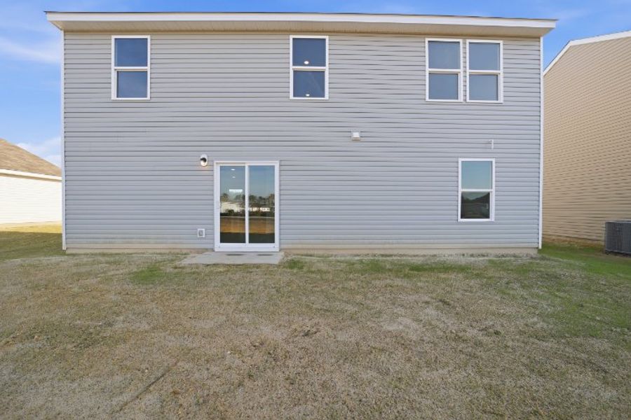 A grey house with a grass yard.