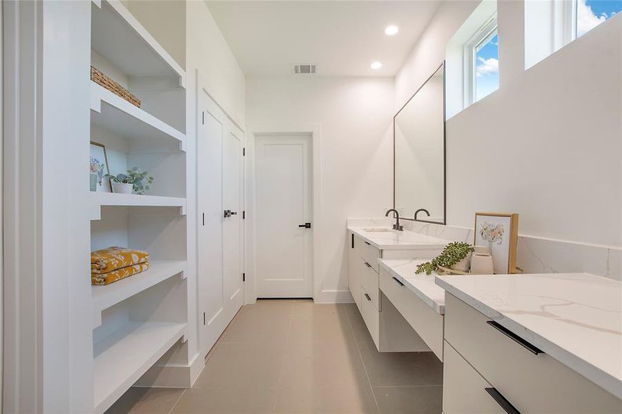 Bathroom featuring tile patterned flooring, built in shelves, and vanity