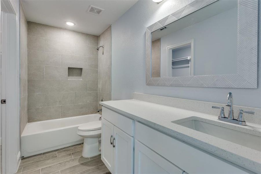 Full bathroom featuring vanity, toilet, and tiled shower / bath