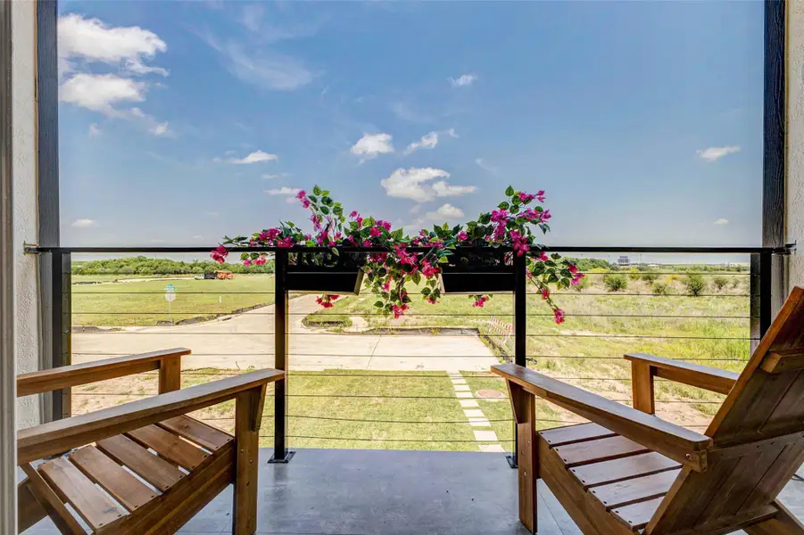 Enjoy peaceful outdoor living from this private balcony retreat, complete with cozy seating and charming planter accents. The open views create a serene backdrop, perfect for morning coffee or evening relaxation. Clean lines and modern railing design enhance the space while maintaining unobstructed sightlines to the surrounding landscape. The picture shown is from the model home with the same floor plan, Rev floor plan.