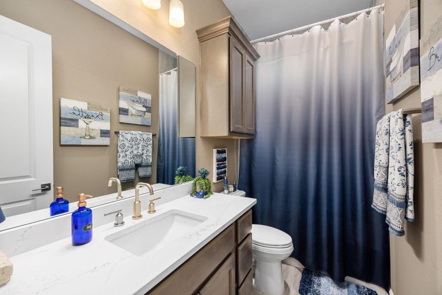 Quartz countertops with 12x24 shower tile from floor to ceiling.