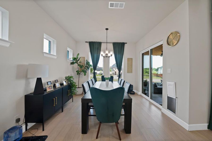 Spacious dining area featuring light wood-finish flooring, recessed lighting, and a chandelier Spacious dining area featuring light wood-finish flooring, recessed lighting, and a chandelier