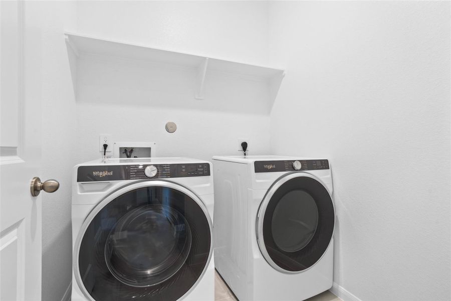 This dedicated laundry room comes equipped with a washer and dryer set, ready for immediate use.