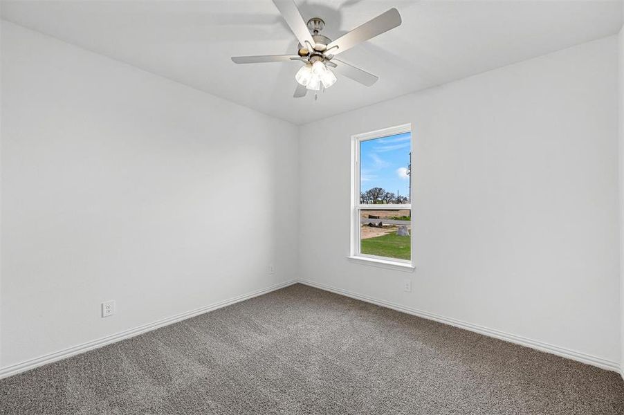 Empty room featuring ceiling fan and carpet