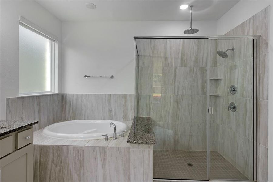 Modern bathroom featuring a built-in soaking tub, a frameless glass shower enclosure, and light-toned tile surrounds
